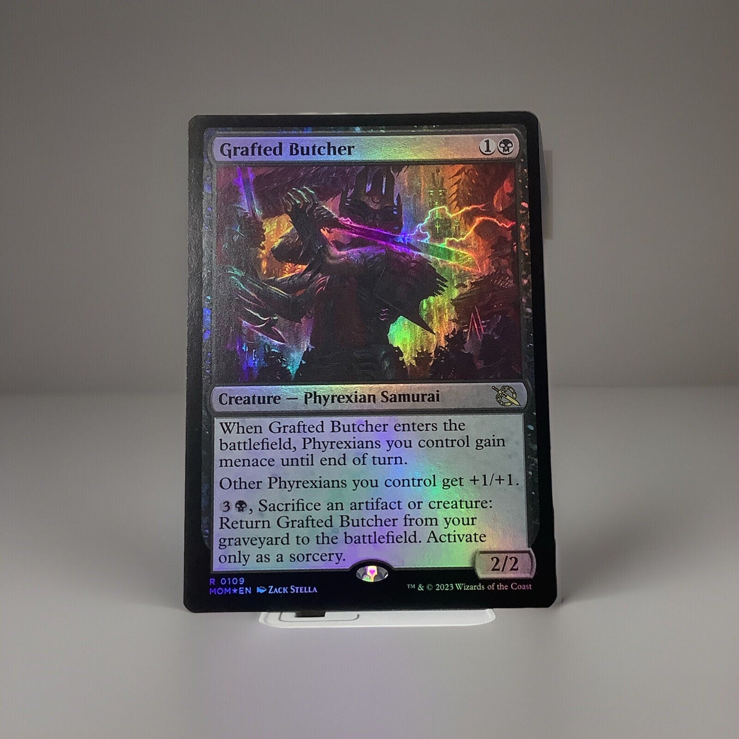 Grafted Butcher Foil MTG card from March of the Machine featuring Phyrexian tribal synergy, menace support, and graveyard recursion.