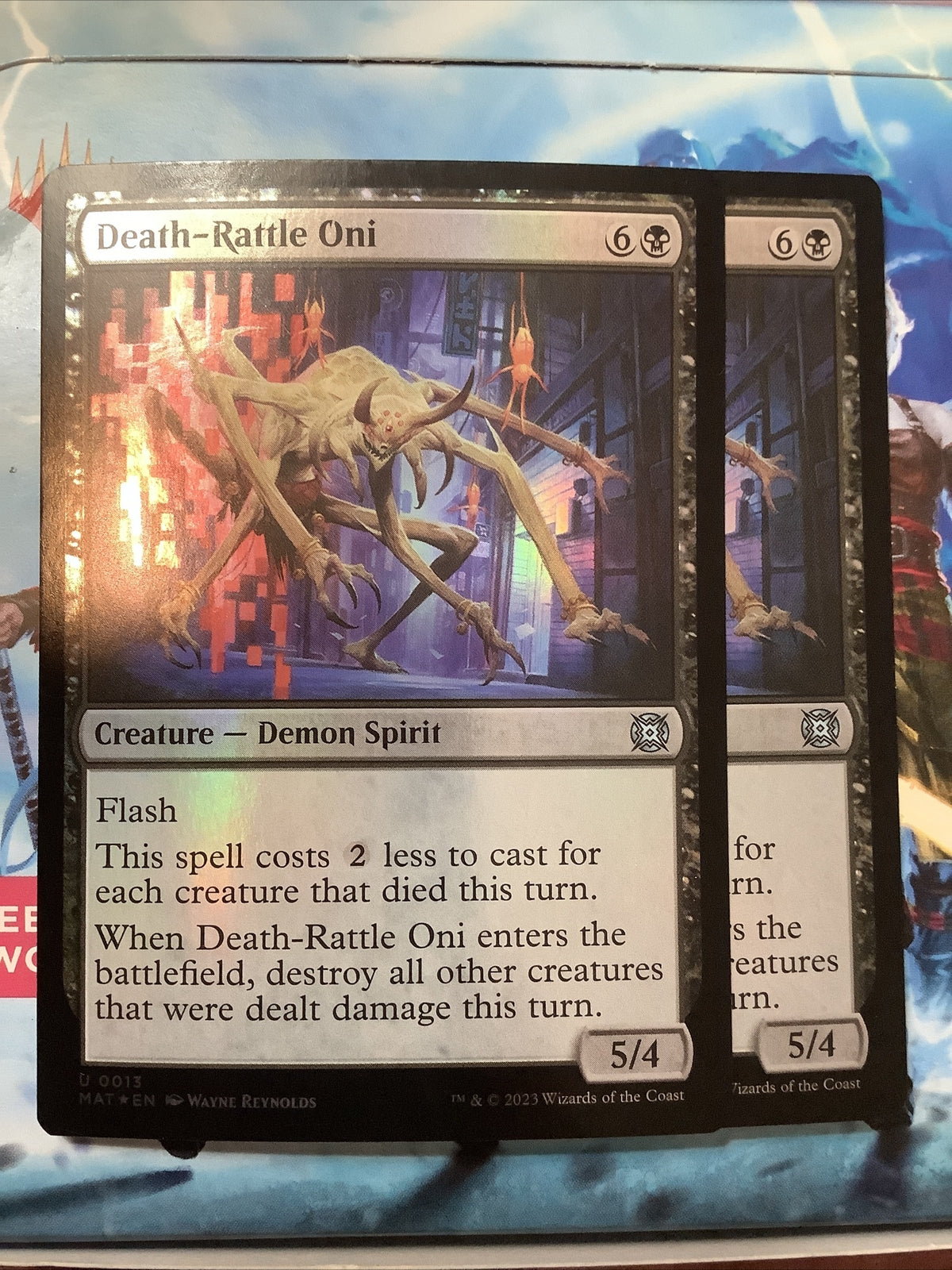 Two foil copies of Death-Rattle Oni MAT 013 mythic demon spirit creature from March of the Machine Aftermath Magic the Gathering set.