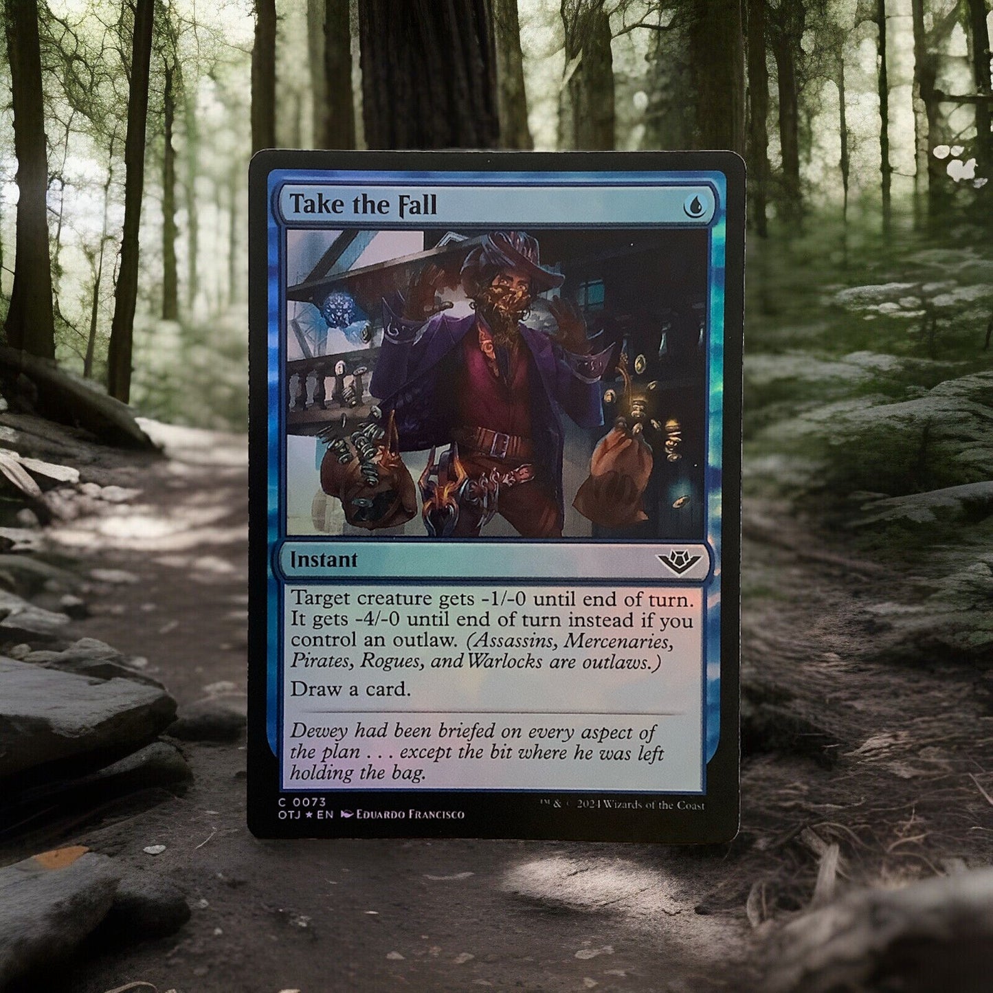 Magic: The Gathering foil Take the Fall instant card from Outlaws of Thunder Junction with reflective blue foil border and outlaw-themed artwork
