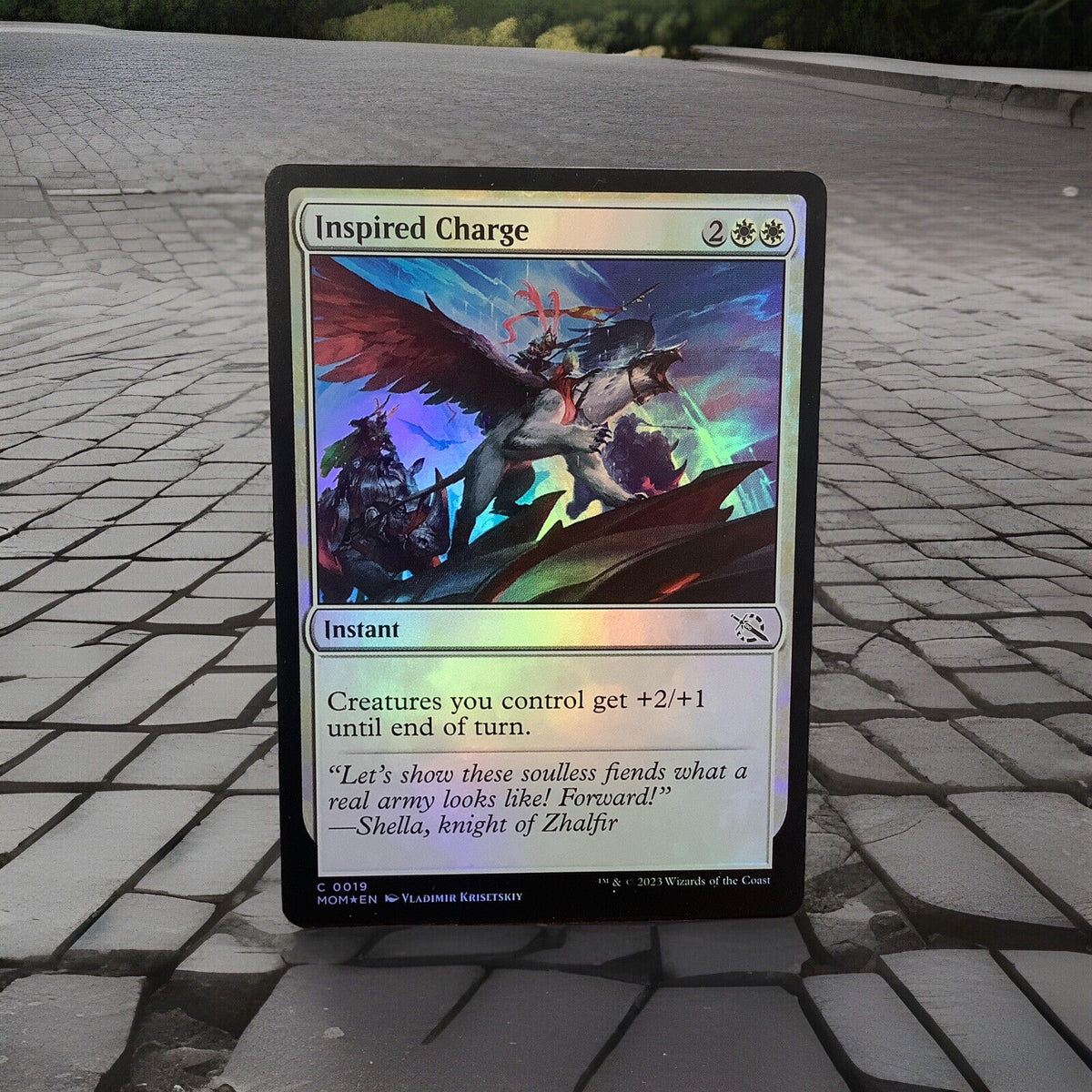 March of the Machine Inspired Charge #19 foil instant featuring team-wide combat buffs, token synergies, and aggressive finisher potential.
