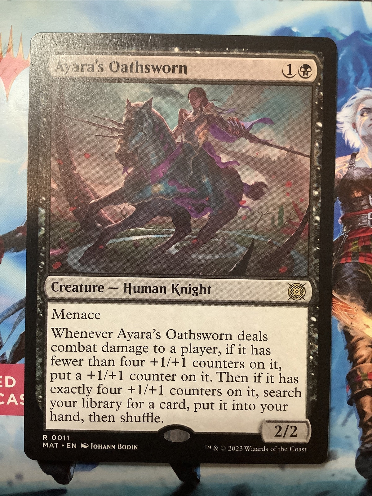 Ayara's Oathsworn MAT 011 regular finish MTG card featuring menace, +1/+1 counter growth, and a powerful tutor reward from March of the Machine The Aftermath.