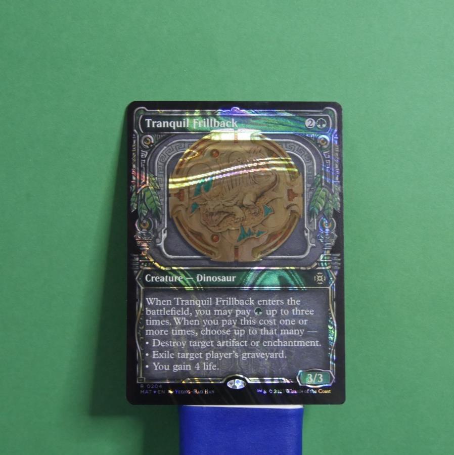 Tranquil Frillback Showcase Halo Foil MTG card from March of the Machine: The Aftermath, Creature Dinosaur 204.
